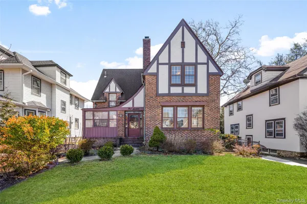 a view of a big house with a big yard and large trees