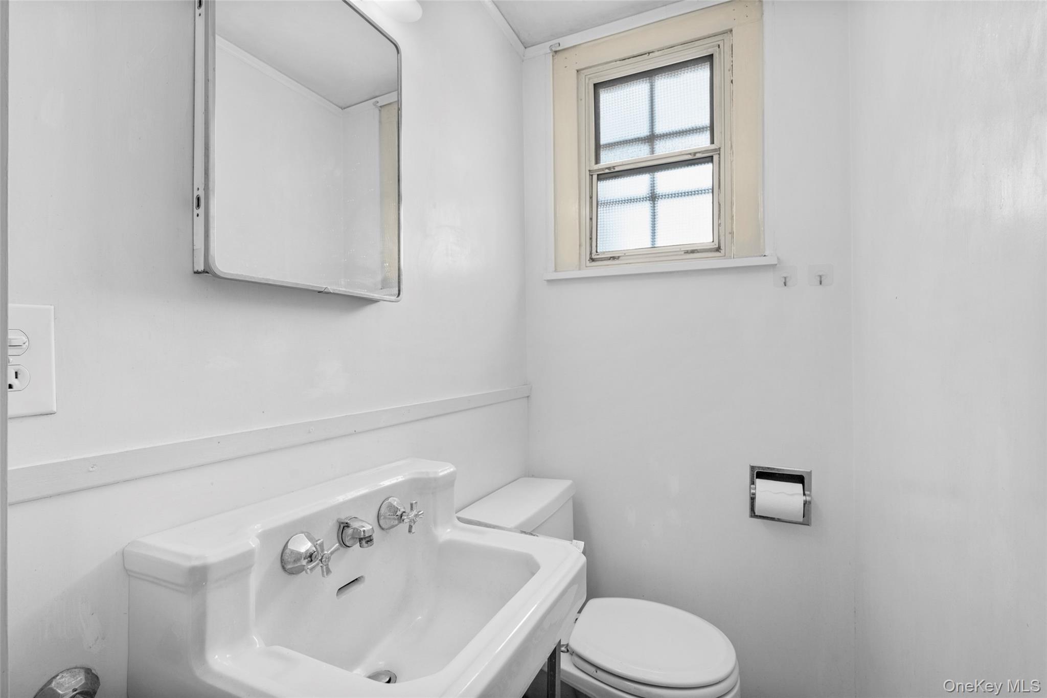 116 Reed Avenue Pelham, NY 10803 - Photo 11 of 22 a bathroom with a sink a toilet and mirror