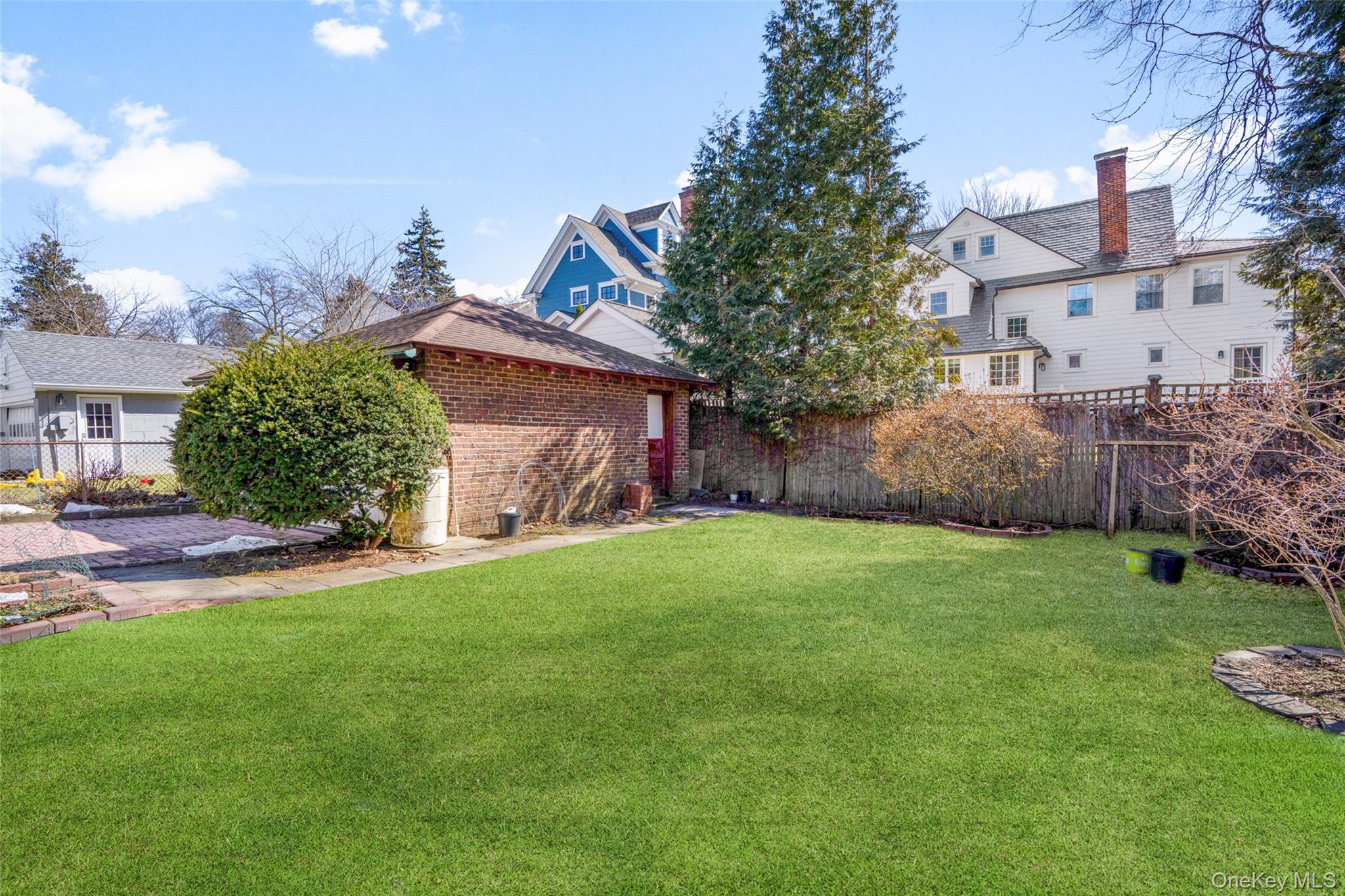 116 Reed Avenue Pelham, NY 10803 - Photo 18 of 22 a view of a backyard with table and chairs and wooden fence