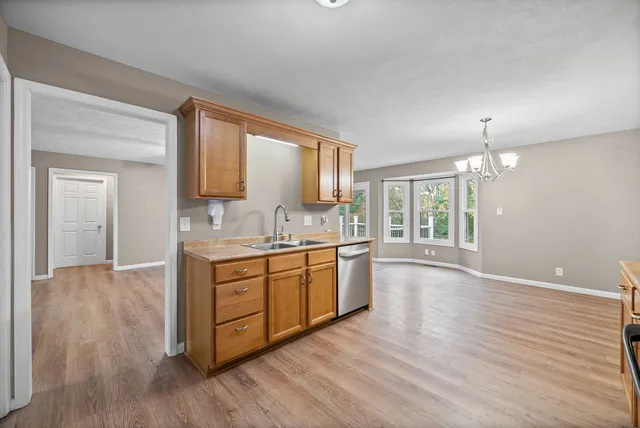 a large kitchen with granite countertop a large window a sink and stainless steel appliances
