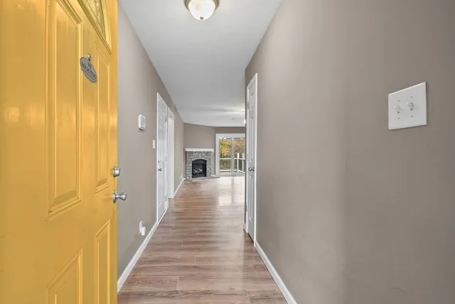 a view of a hallway with wooden floor and staircase