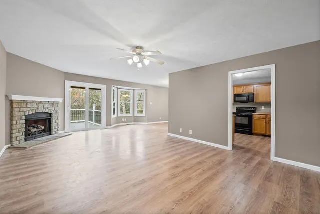 a view of an empty room with a window and fireplace