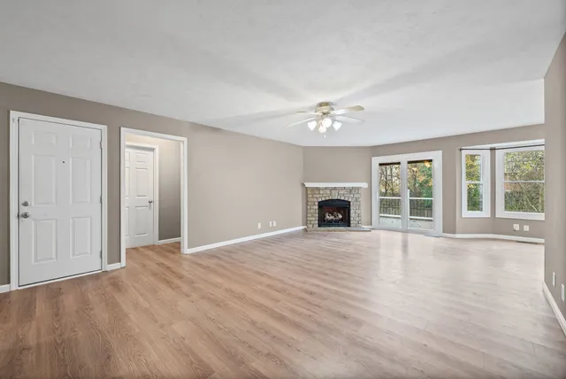 a view of an empty room with a window and fireplace