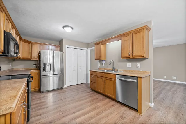 a kitchen with granite countertop a refrigerator stove top oven and sink
