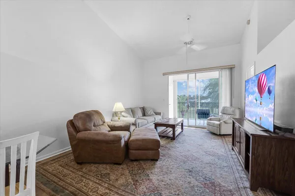 a living room with furniture two window and a flat screen tv