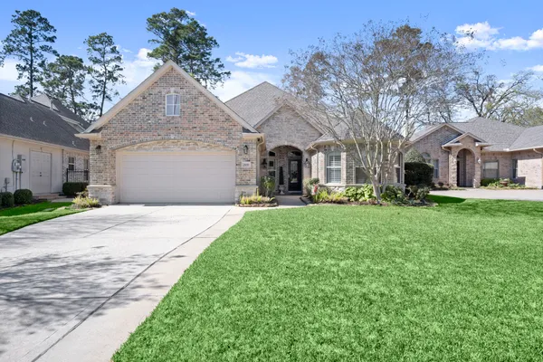 a front view of a house with a yard and trees