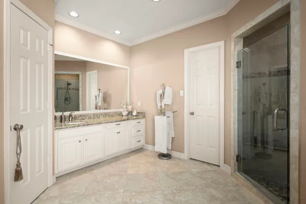 a bathroom with a granite countertop sink a mirror and a shower