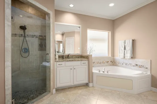a bathroom with a tub sink shower and mirror