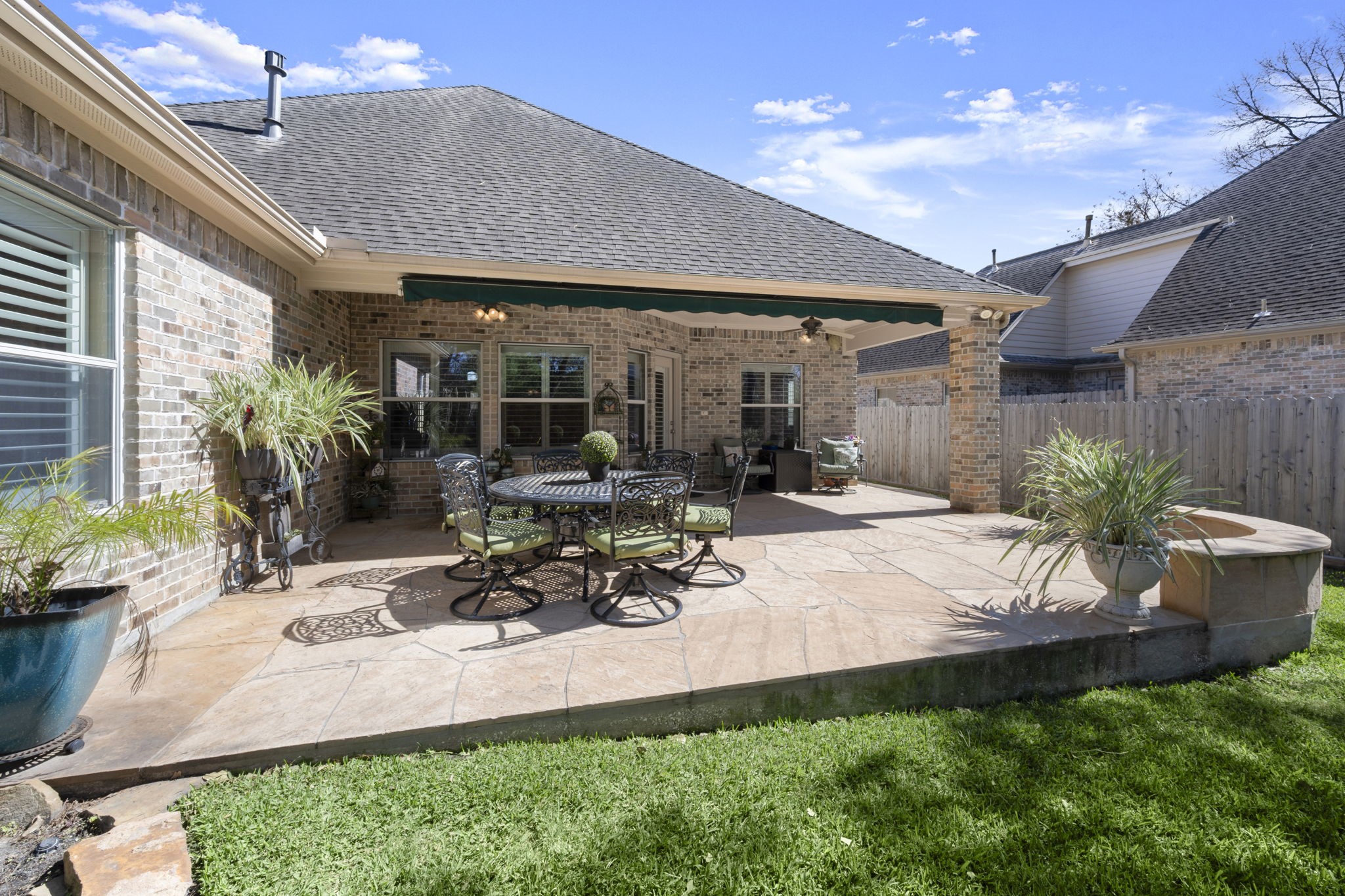 25051 Bow Wood Court Spring, TX 77389 - Photo 20 of 22 a view of a patio with table and chairs potted plants and floor to ceiling window