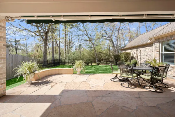 a view of backyard with table and chairs and potted plants