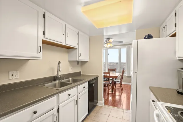 a kitchen with granite countertop a sink a stove and refrigerator