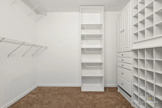 a view of walk in closet with empty racks