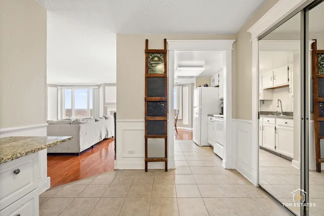 a large white kitchen with granite countertop a refrigerator and a sink