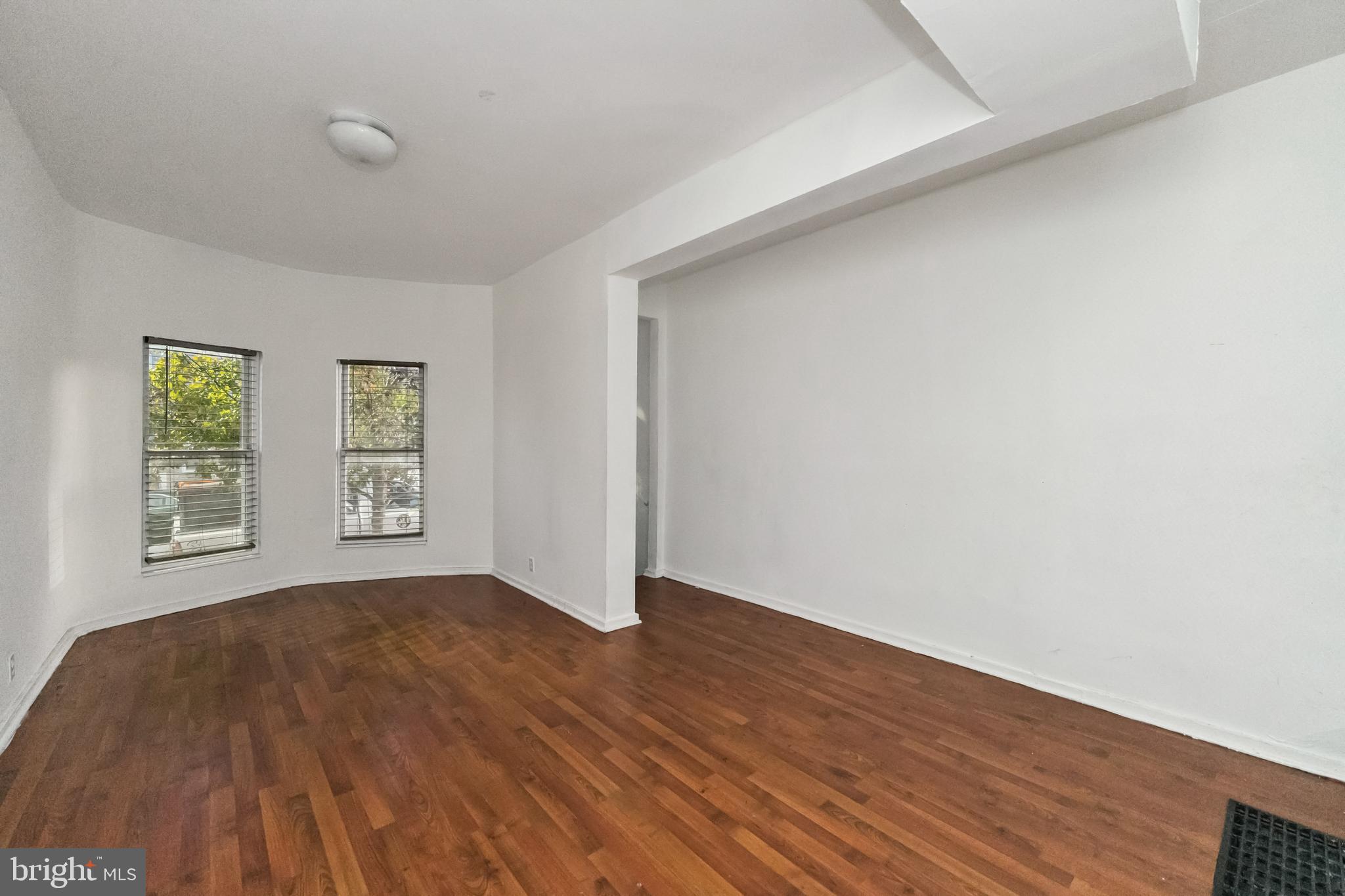 1828 Walbrook Avenue Baltimore, MD 21217 - Photo 6 of 15 an empty room with wooden floor and windows