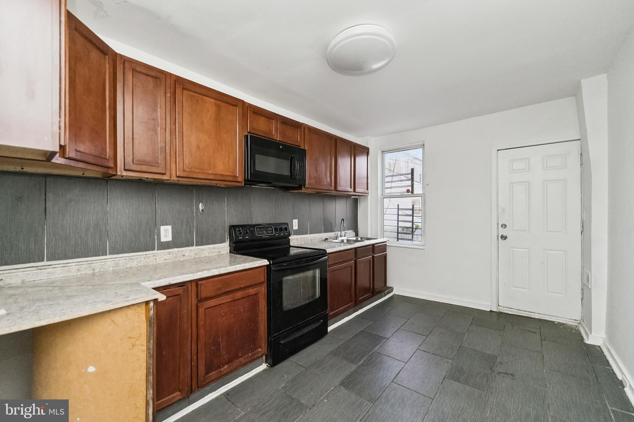 1828 Walbrook Avenue Baltimore, MD 21217 - Photo 8 of 15 a kitchen with stainless steel appliances granite countertop a stove a sink and a microwave