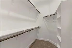 a view of an empty room with a window and a kitchen