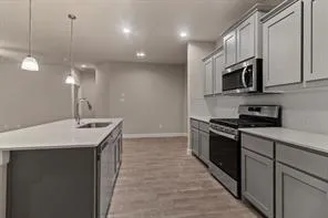 a kitchen with stainless steel appliances granite countertop a sink a stove and a refrigerator