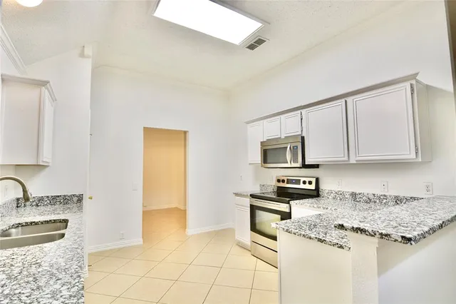a kitchen with stainless steel appliances granite countertop a stove and a sink