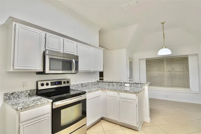 a kitchen with granite countertop a stove sink and microwave