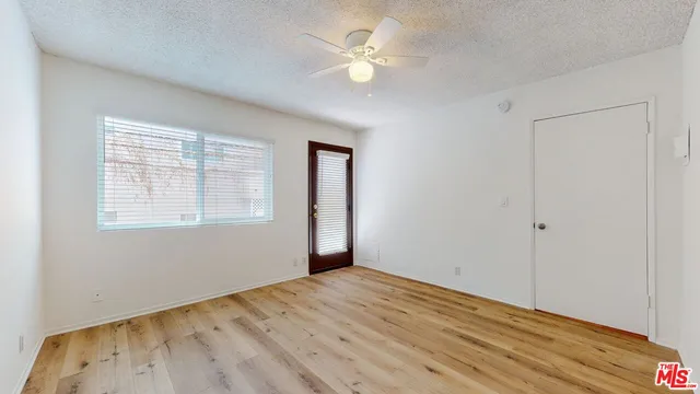 a view of empty room with wooden floor