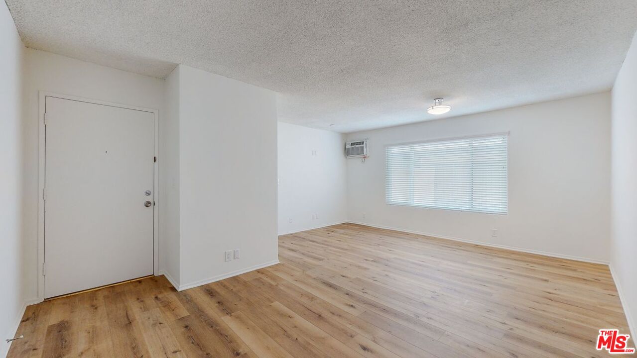 1827 Manning Avenue, Unit 6 Los Angeles, CA 90025 - Photo 5 of 22 a view of an empty room with wooden floor and a window