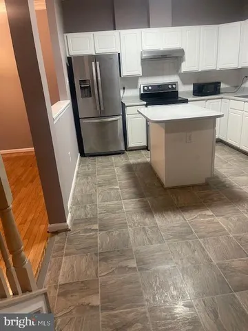 a kitchen with a sink a refrigerator a microwave and cabinets