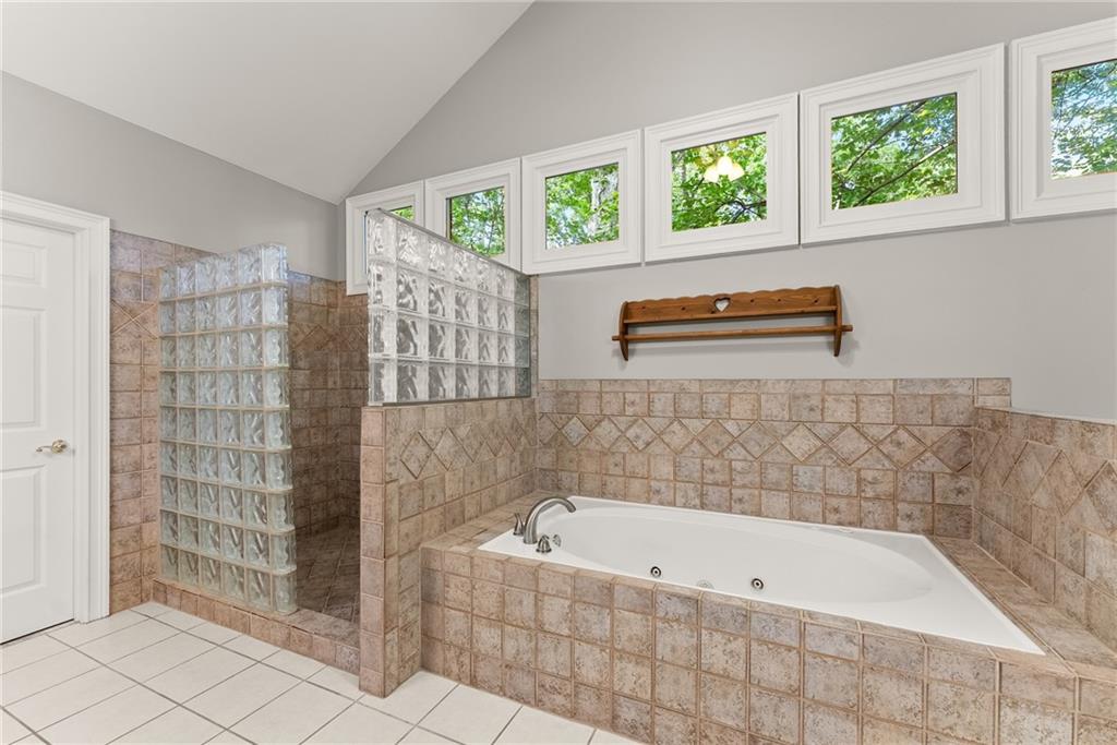 1040 Auburn Road Dacula, GA 30019 - Photo 27 of 65 a bathroom with a bathtub and a shower