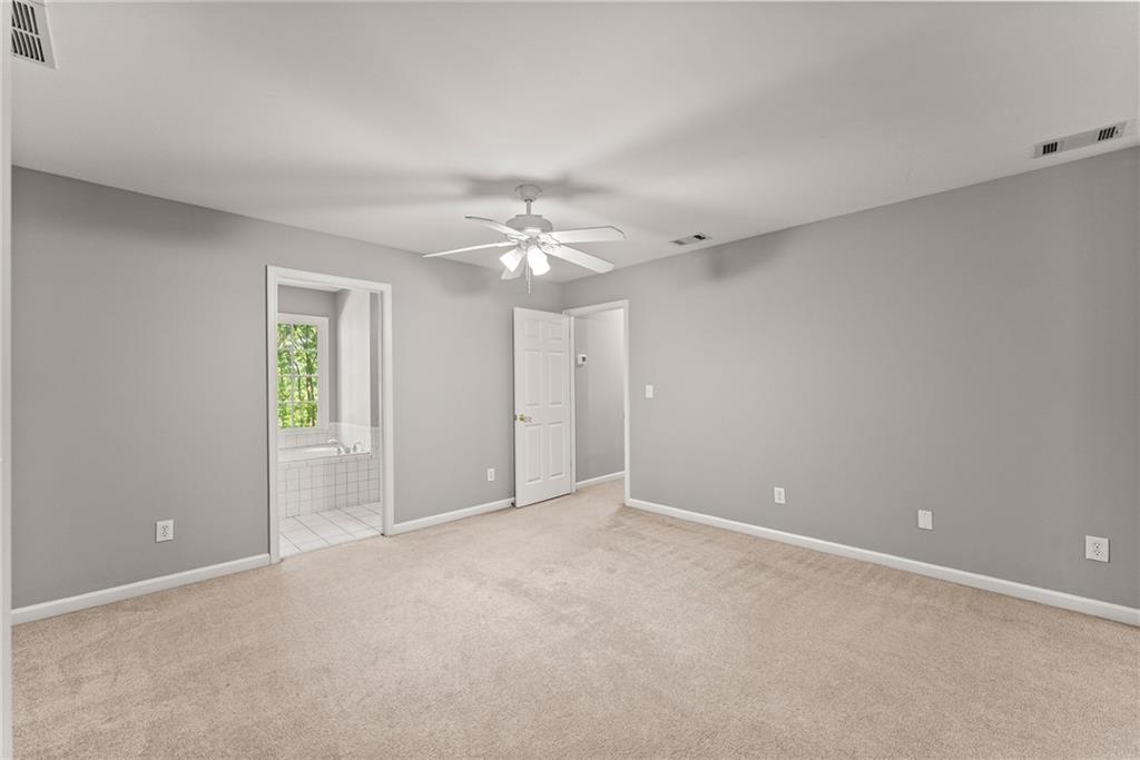 1040 Auburn Road Dacula, GA 30019 - Photo 36 of 65 an empty room with chandelier fan and windows