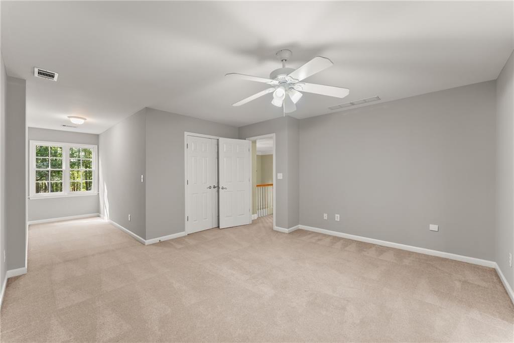 1040 Auburn Road Dacula, GA 30019 - Photo 37 of 65 an empty room with a ceiling fan and a window