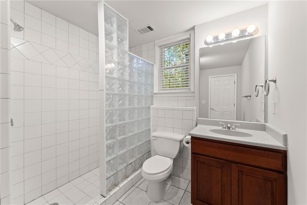 1040 Auburn Road Dacula, GA 30019 - Photo 49 of 65 a bathroom with a sink a toilet and shower