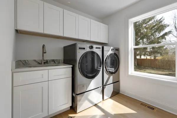 a utility room with sink dryer and washer