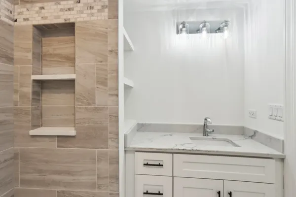 a bathroom with a granite countertop sink and mirror