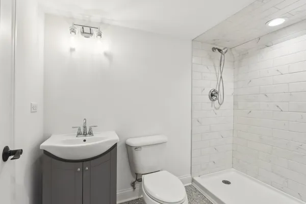 a bathroom with a shower sink mirror and toilet