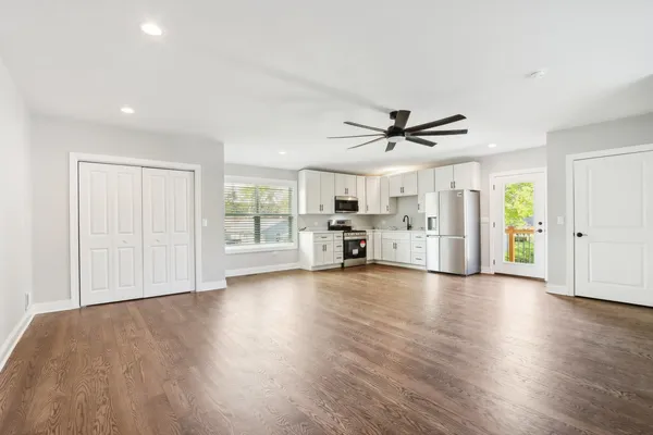 a view of empty room with wooden floor and ceiling fan