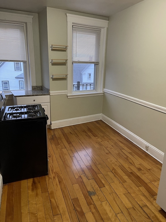 a view of kitchen with wooden floor and cabinets