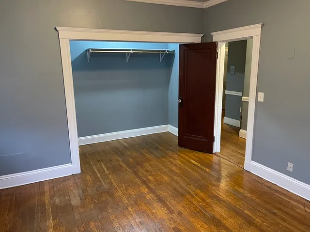 an empty room with wooden floor and closet