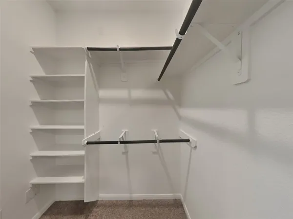 a view of walk in closet with empty racks
