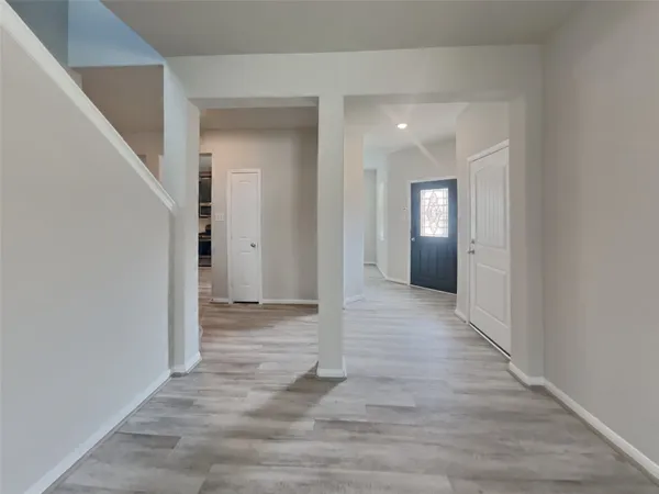 a view of a hallway with wooden floor and staircase