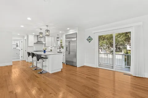 a kitchen with stainless steel appliances granite countertop a stove and a wooden floors