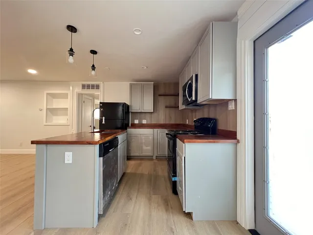 a kitchen with kitchen island granite countertop a sink cabinets and stainless steel appliances