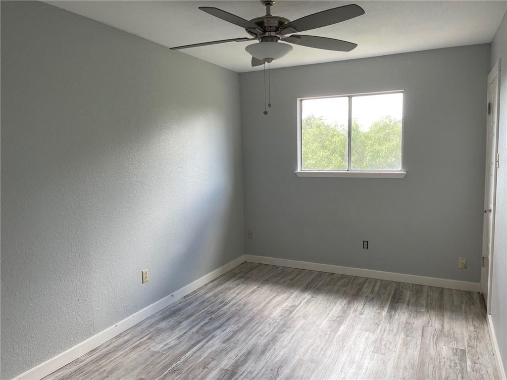 11605 Post Oak Circle, Unit 2 Corpus Christi, TX 78410 - Photo 6 of 7 an empty room with a window and wooden floor