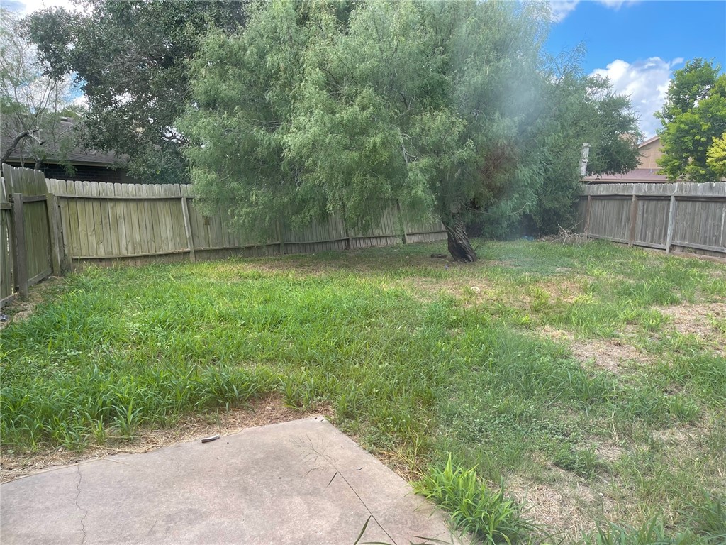 11605 Post Oak Circle, Unit 2 Corpus Christi, TX 78410 - Photo 7 of 7 a backyard of a house with plants and large tree