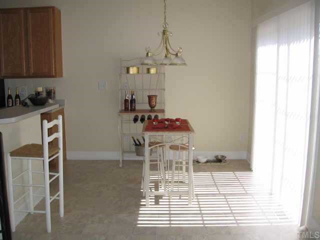 2605 Alder Ridge Lane Raleigh, NC 27603 - Photo 2 of 10 Spacious breakfast nook will easily sit 6 comfortably plus extra seating at the raised bar! Quick access to the back deck!