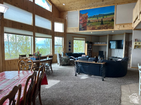 1940 East Shore Road St. Charles, ID 83272 - Photo 25 of 64 Carpeted living room featuring a vaulted wooden ceiling and wood walls