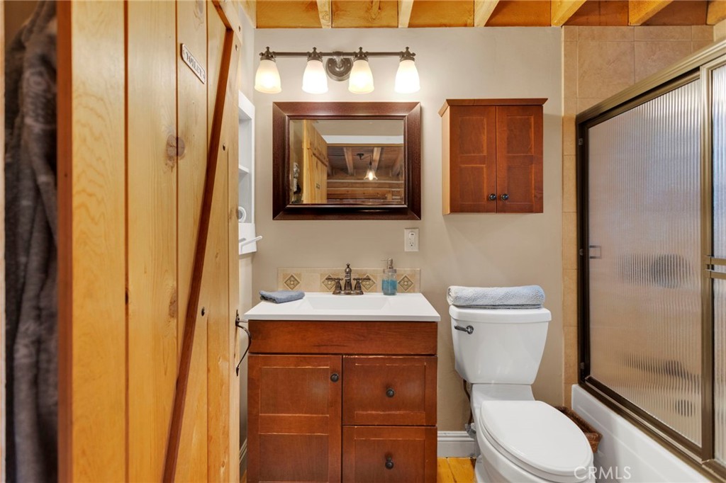 788 Buckingham Square Lake Arrowhead, CA 92352 - Photo 33 of 61 a bathroom with a toilet sink vanity and mirror