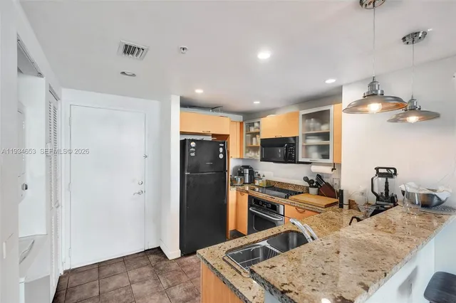 a kitchen with stainless steel appliances granite countertop a refrigerator and a sink