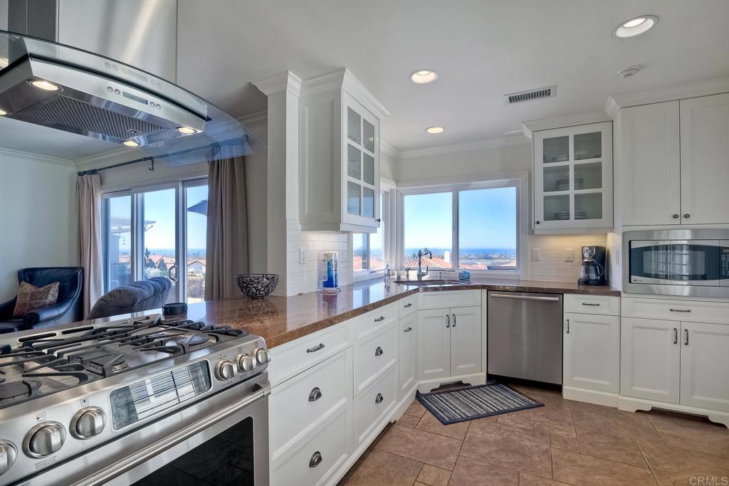 a large kitchen with stainless steel appliances granite countertop a stove and a sink