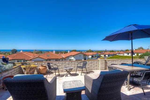 a view of a patio with a table and chairs under an umbrella