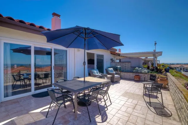 a view of a patio with couches chairs under an umbrella