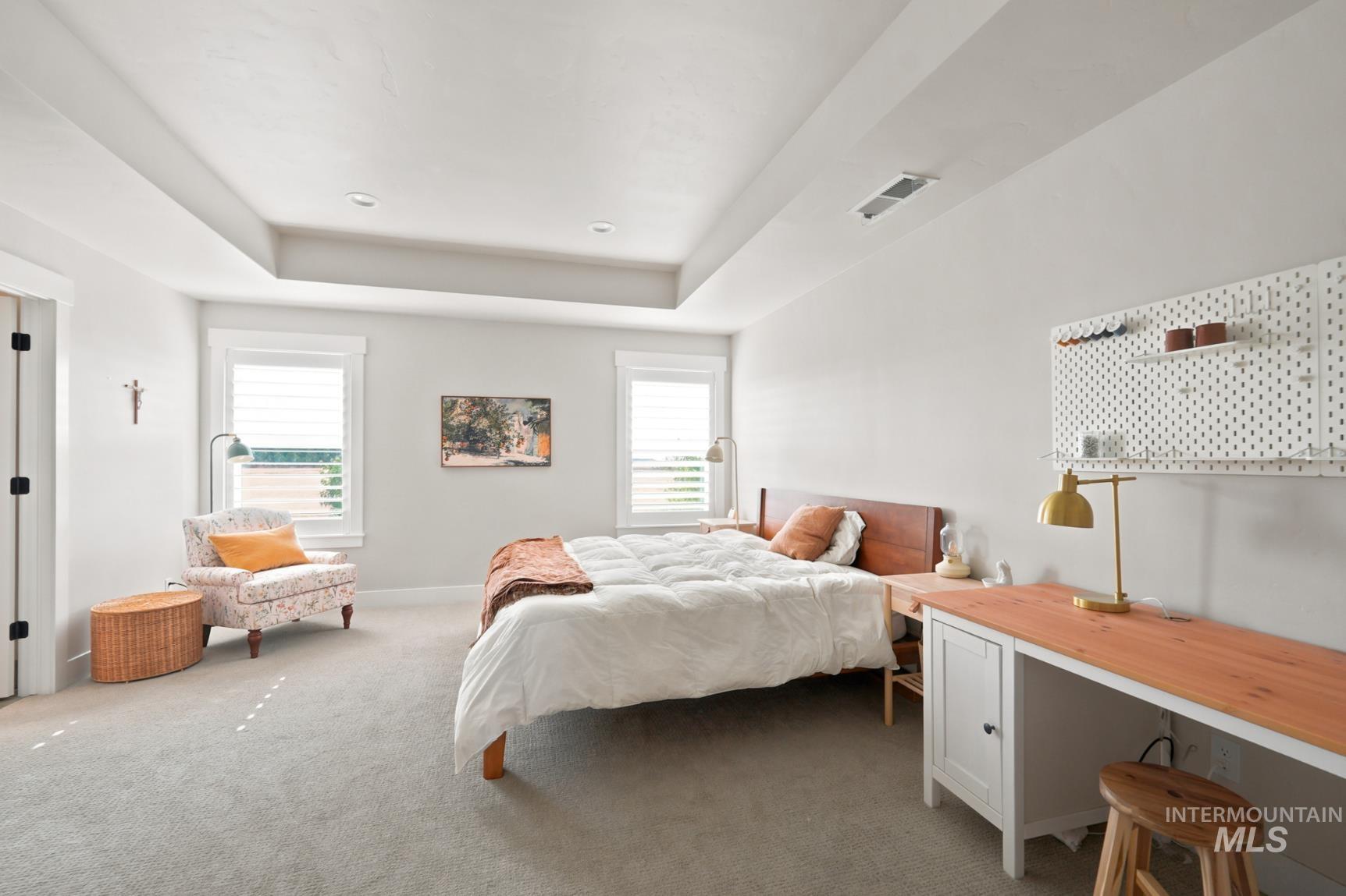 6933 South Zenith Avenue Meridian, ID 83642 - Photo 26 of 34 Recessed lighting illuminates the tray ceiling in this carpeted room, featuring white walls, white window shutters, and a white pegboard organization system